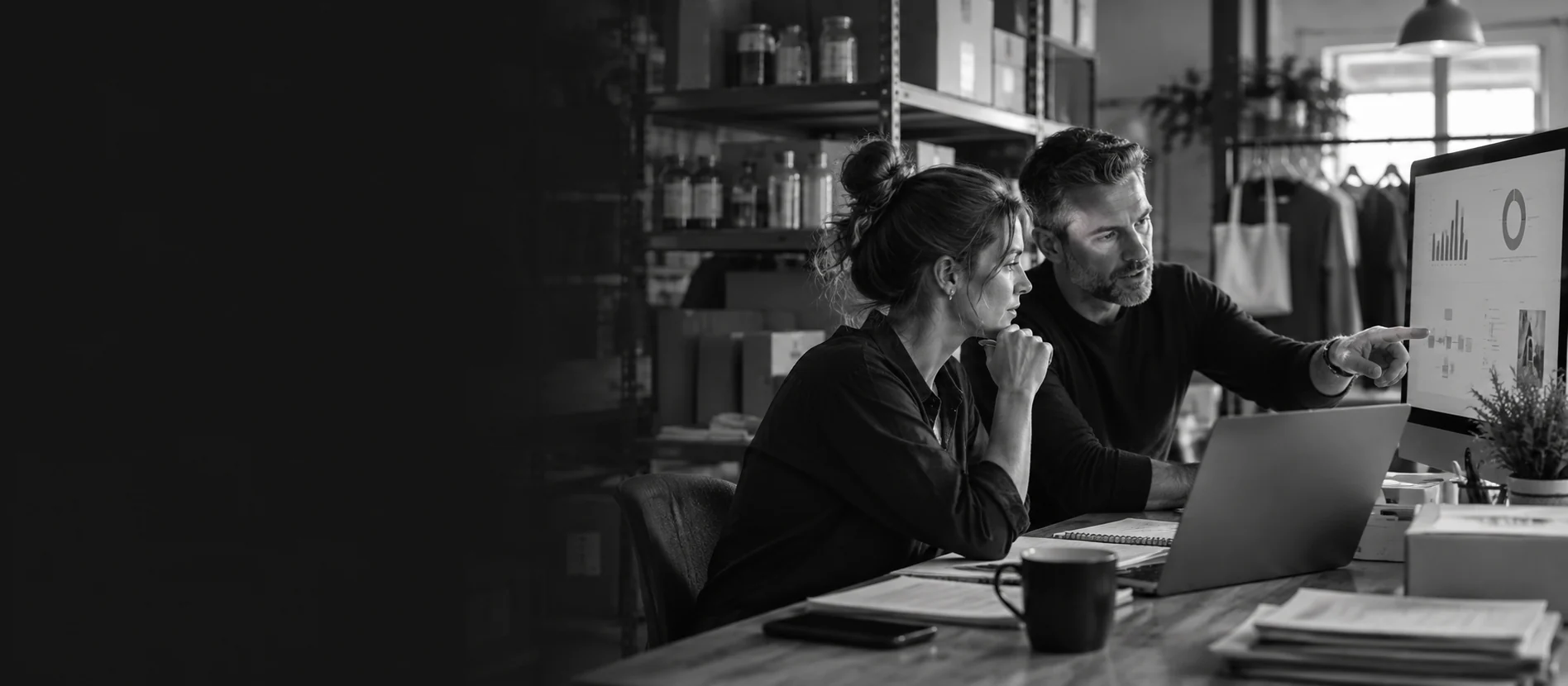 Two people reviewing business information on a computer